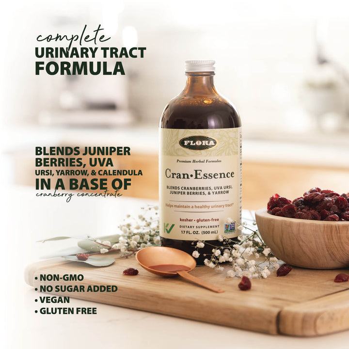 UTI liquid supplement with cranberries, uva ursi, juniper berries, and yarrow to support urinary tract health, pictured with cranberries and herbs